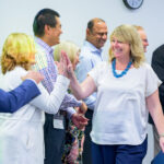 Incyte workers high-five one another after "graduation."