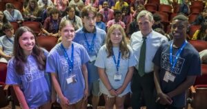 Four teens stand with the governor