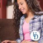 Young girl working on a laptop.