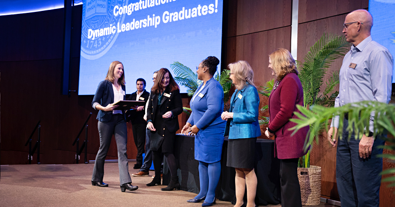 Graduates of a new course take the stage to receive their diplomas.