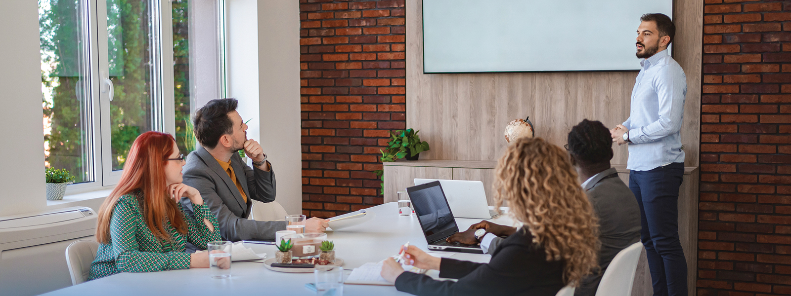 Professionals around conference table discussing a presentation