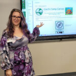 Julie Eller standing in front of screen with her instructional design content is projected.