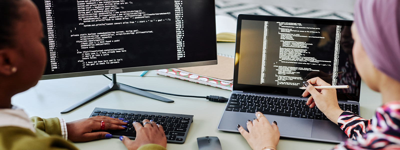 two young women programmers working at a computer 